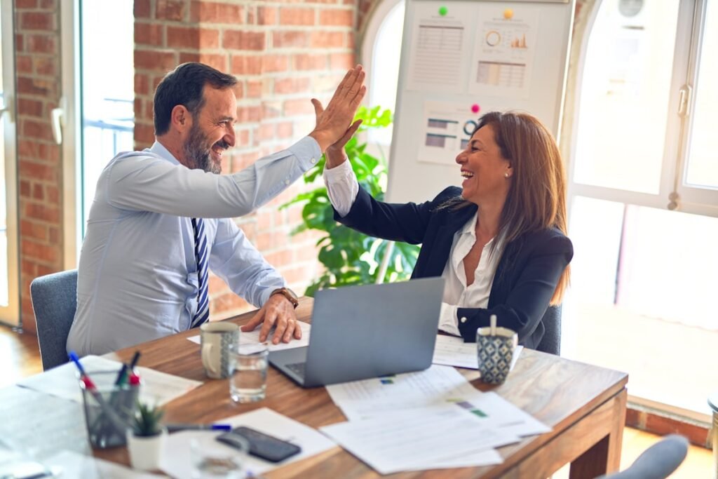 Local business owners celebrating growth results with a high five